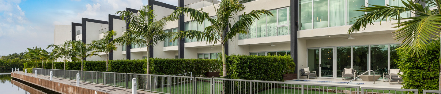 row of houses each one with a front garden and poolside