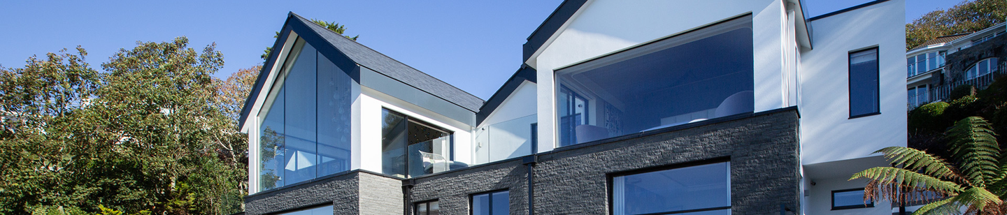 Modern house with decking, deck chairs, and large windows in Fort George